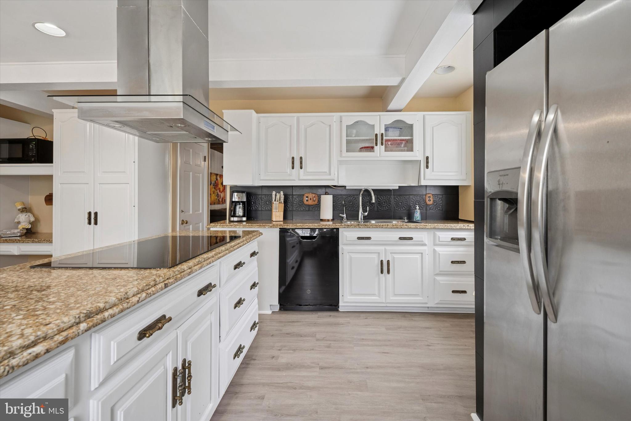 125 Red Lion Road Huntingdon Valley, PA 19006 - Photo 9 of 32 a kitchen with stainless steel appliances kitchen island granite countertop a refrigerator a sink and white cabinets