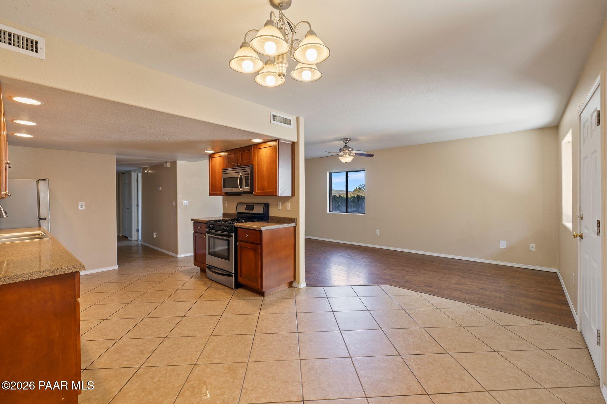 1001 East Goodwin Street, Unit 101 Prescott, AZ 86303 - Photo 18 of 23 a kitchen with stainless steel appliances granite countertop a stove top oven a sink a counter space and cabinets