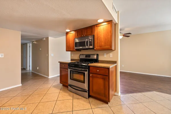 a kitchen with stainless steel appliances granite countertop a stove a sink and a microwave
