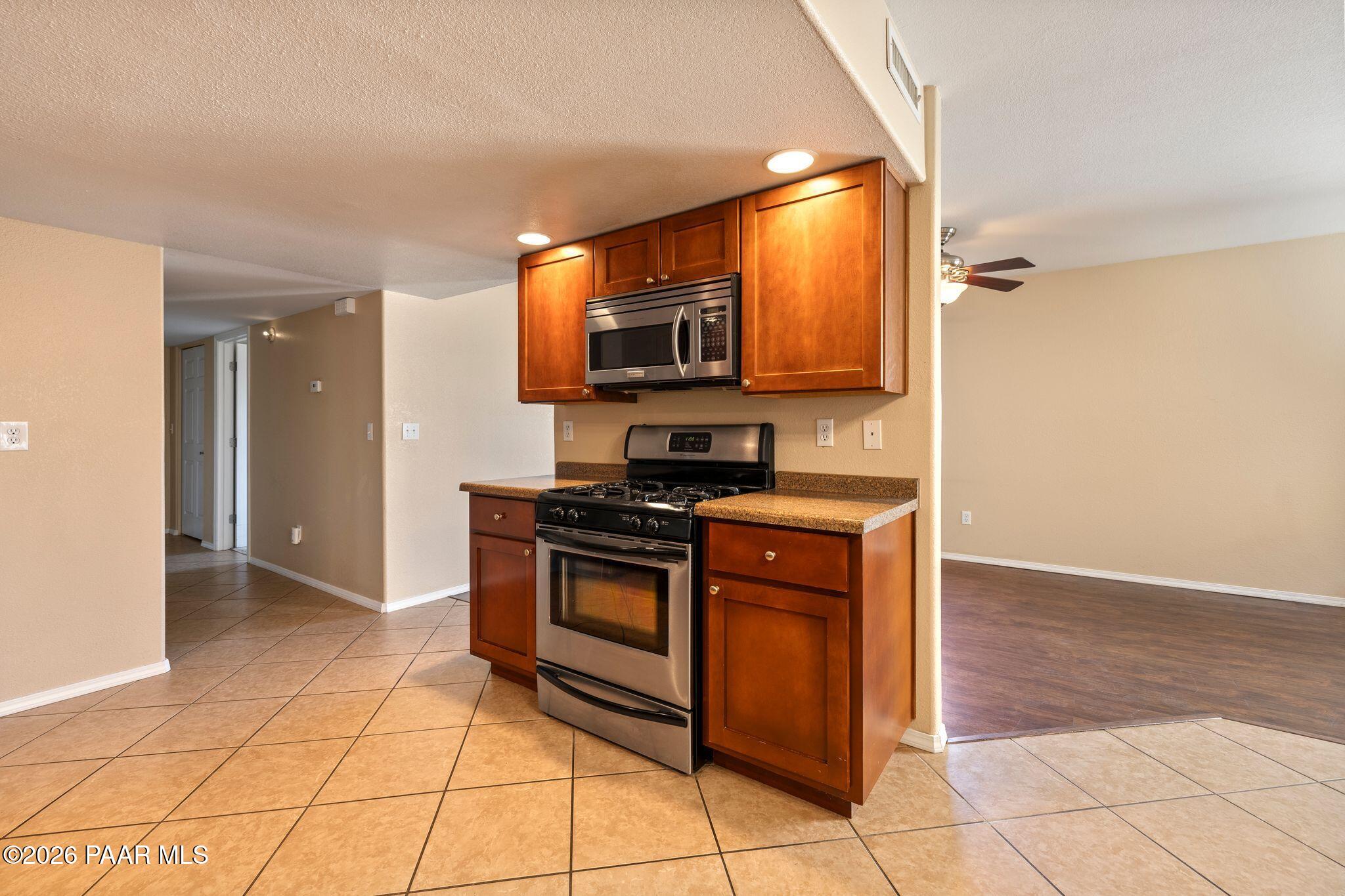 1001 East Goodwin Street, Unit 101 Prescott, AZ 86303 - Photo 6 of 23 a kitchen with stainless steel appliances granite countertop a stove a sink and a microwave