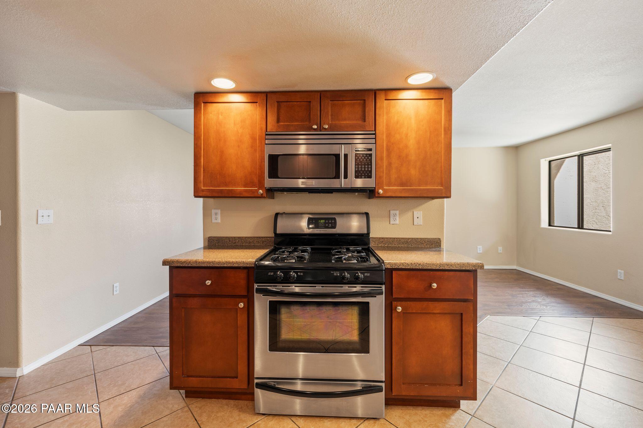 1001 East Goodwin Street, Unit 101 Prescott, AZ 86303 - Photo 7 of 23 a kitchen with granite countertop a stove and a microwave