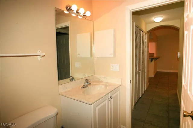 an empty room with a chandelier fan and windows