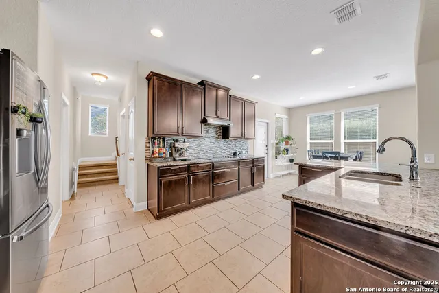 a kitchen with stainless steel appliances granite countertop a stove a sink and a refrigerator