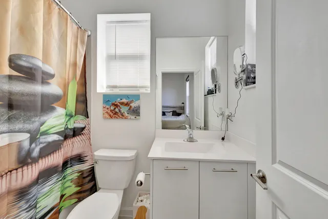 a bathroom with a sink a toilet and shower curtain