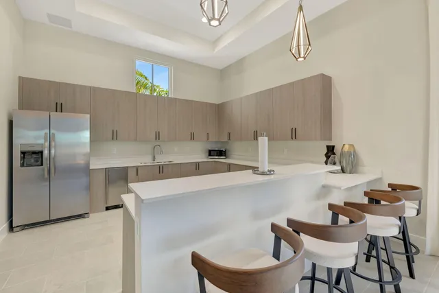 a kitchen with a dining table chairs and refrigerator