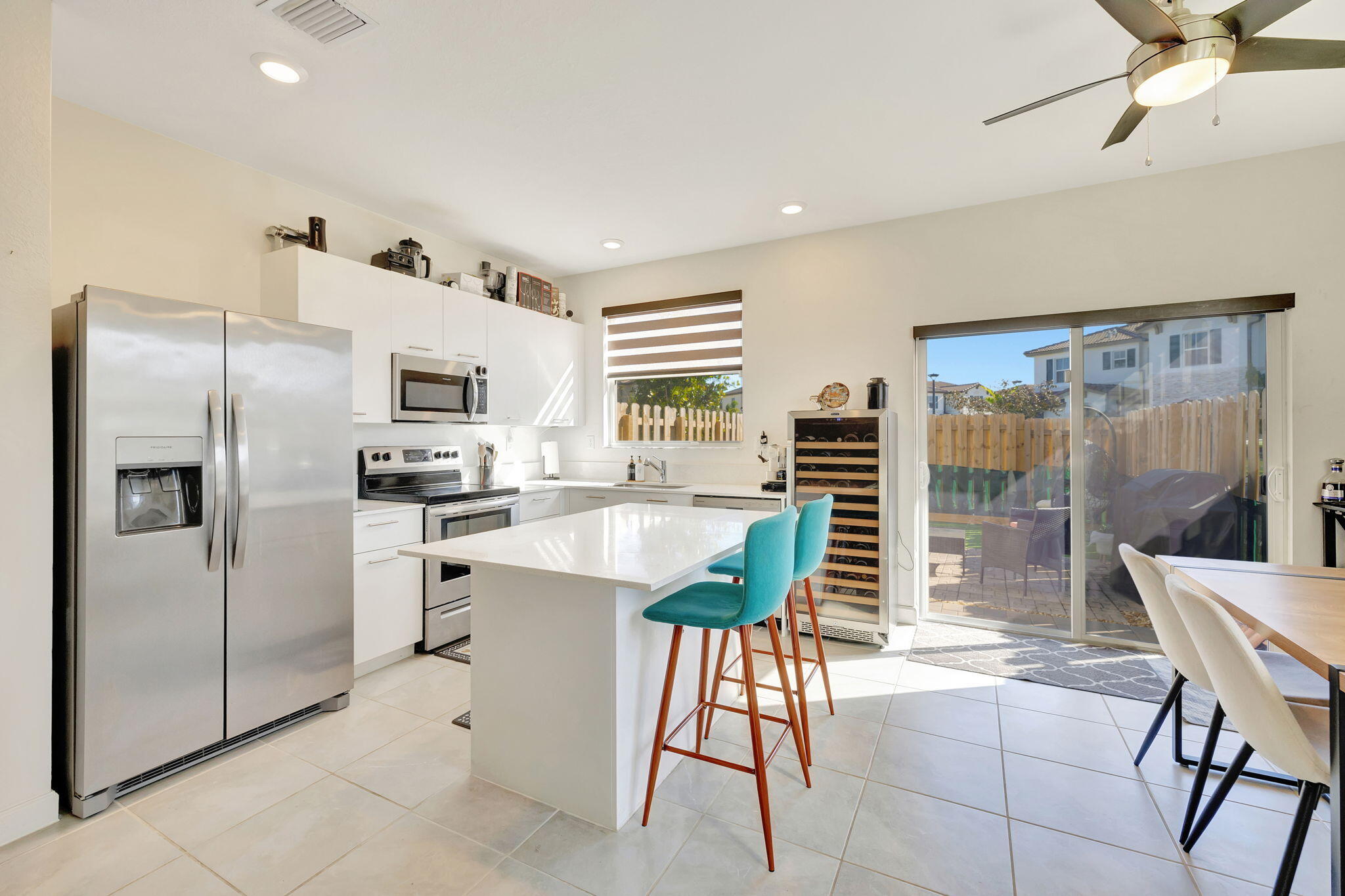 12227 Northwest 23rd Avenue Miami, FL 33167 - Photo 7 of 52 a kitchen with stainless steel appliances a refrigerator a stove a sink and a dining table with garden view