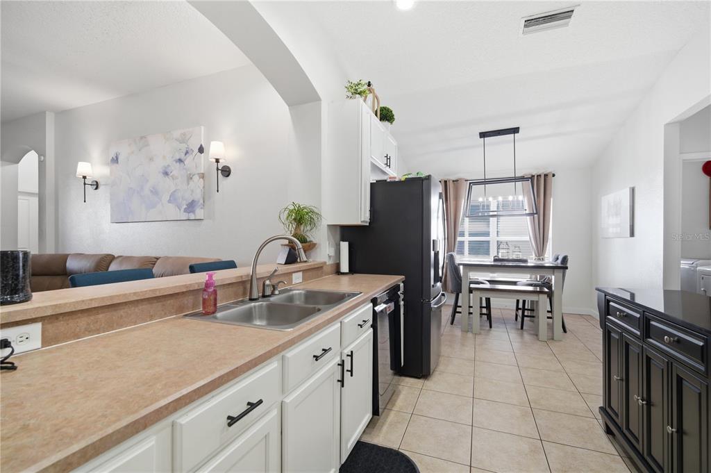 6325 Bridgecrest Drive Lithia, FL 33547 - Photo 15 of 72 a kitchen with stainless steel appliances granite countertop a refrigerator a sink a stove and a dining table with wooden floor