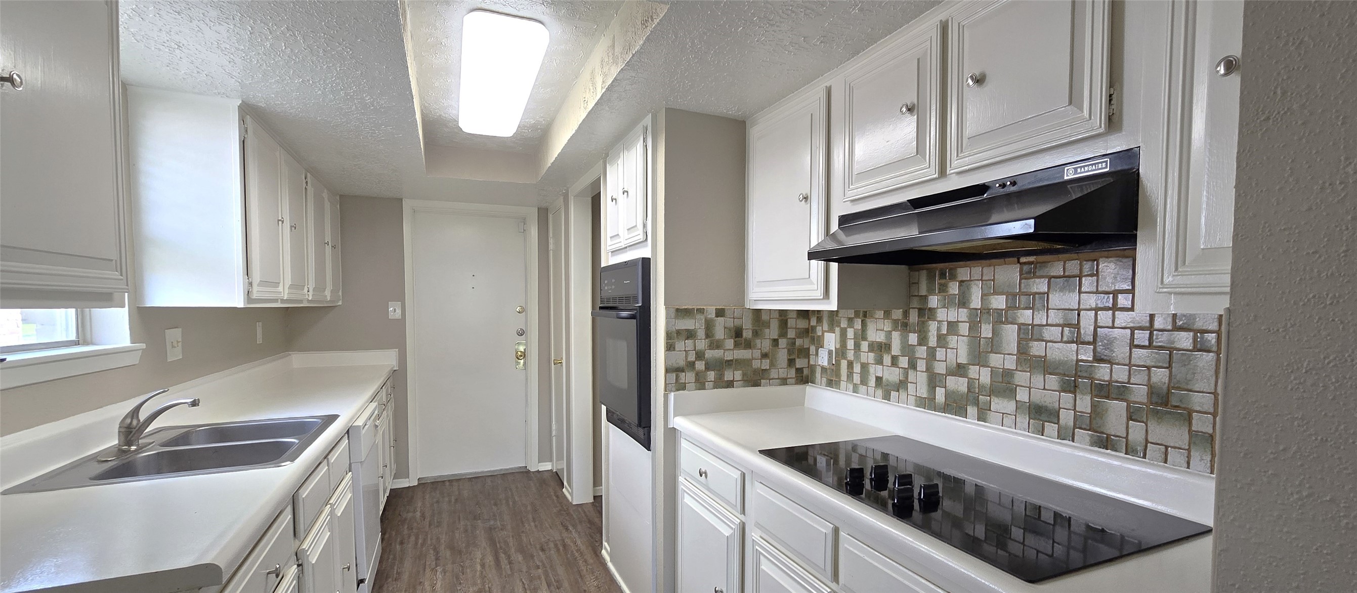 23019 Tree Bright Lane Spring, TX 77373 - Photo 7 of 20 Kitchen includes a dishwasher, an electric cooktop and oven, a pantry and nice tiled backsplash. The door leads to the 2-car attached garage. Utility Room in garage.