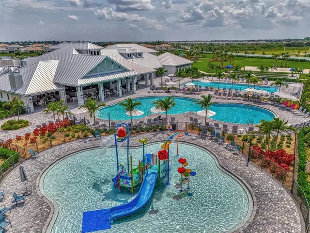 an aerial view of a residential houses with outdoor space and a lake view