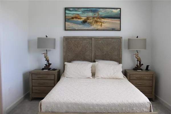 a bedroom with a bed and a painting on the wall
