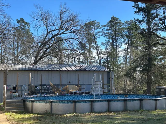 a house view with swimming pool and a yard