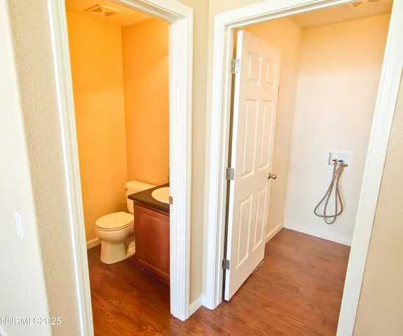 a view of a hallway with wooden floor and a ceiling fan