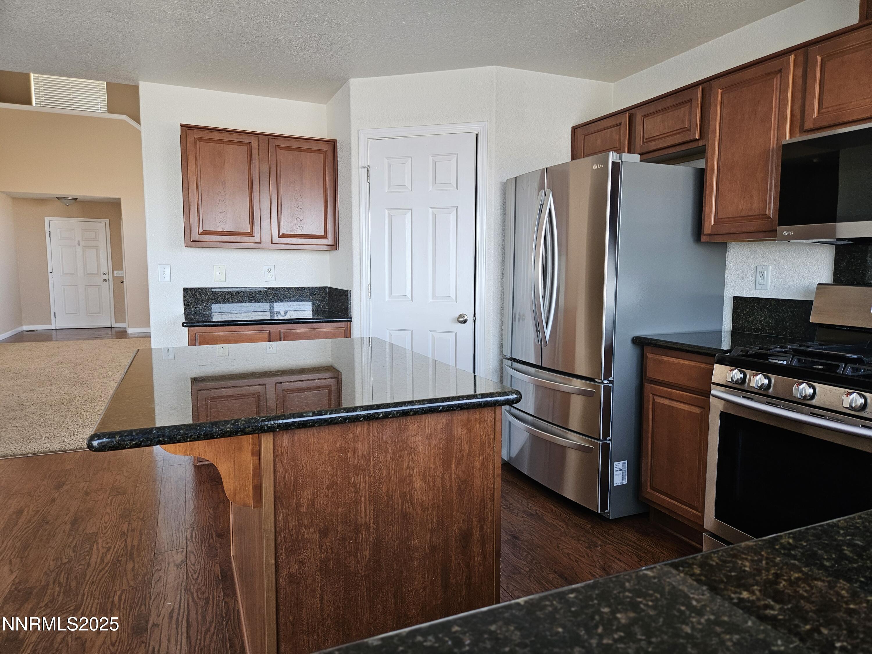 7900 Beech Street Silver Springs, NV 89429 - Photo 5 of 37 a kitchen with granite countertop a refrigerator stove and microwave