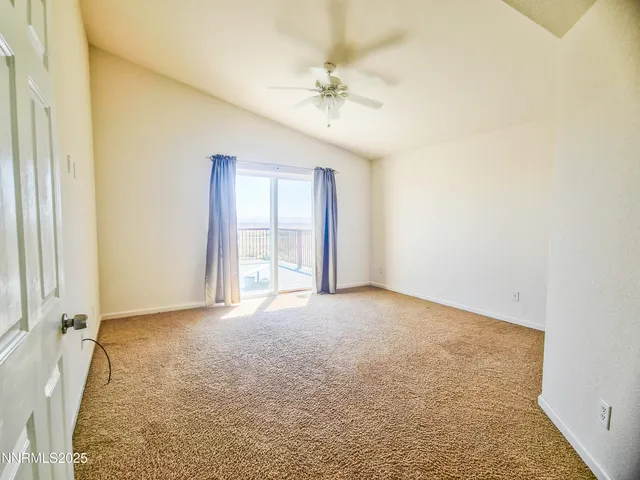 an empty room with a ceiling fan and a window