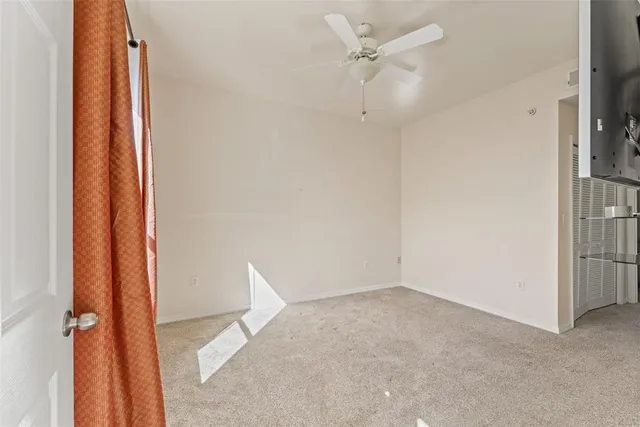 an empty room with wooden floor and ceiling fan