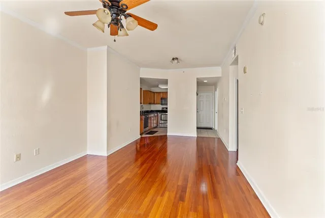 a view of a room with wooden floor and a ceiling fan