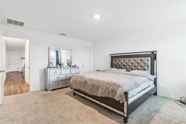 a bed room with a bed and a view of kitchen