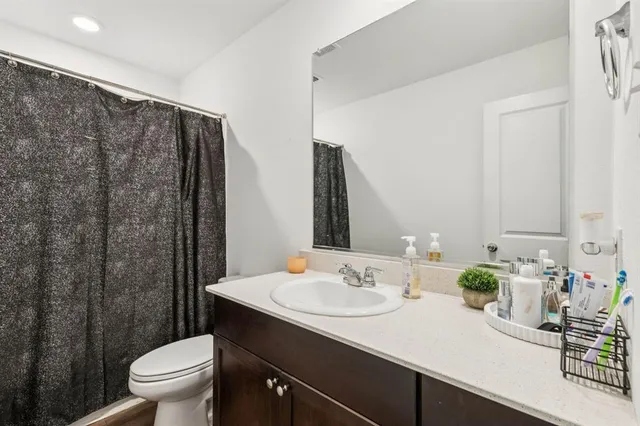 a bathroom with a granite countertop sink a toilet and a mirror
