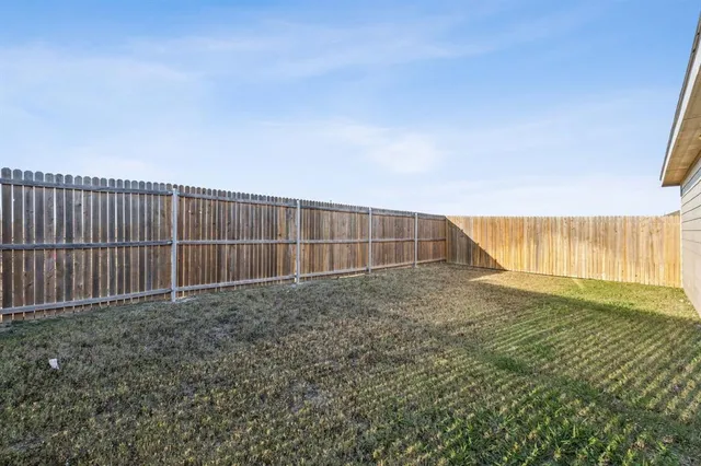 a view of backyard with wooden fence