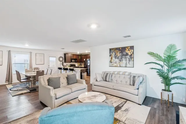 a living room with furniture and a large mirror with wooden floor