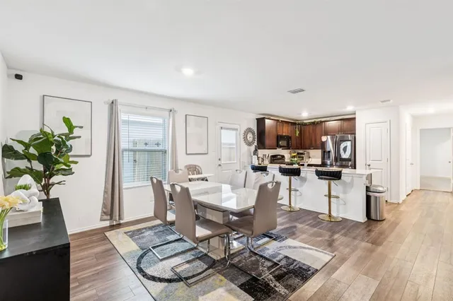 a living room with furniture a dining table and a potted plant