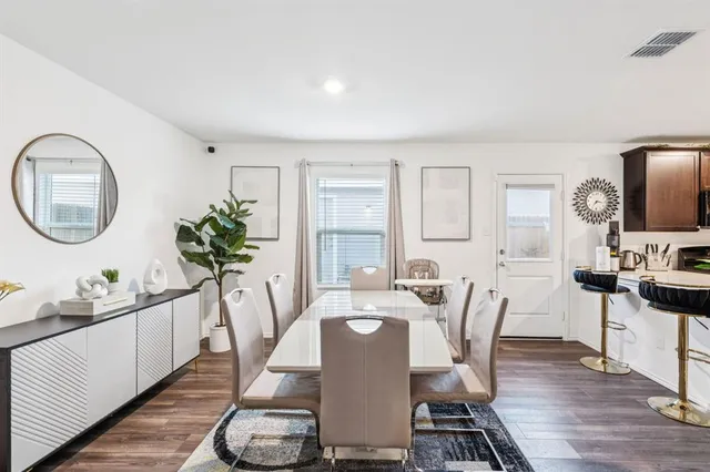a dining room with furniture a mirror and wooden floor