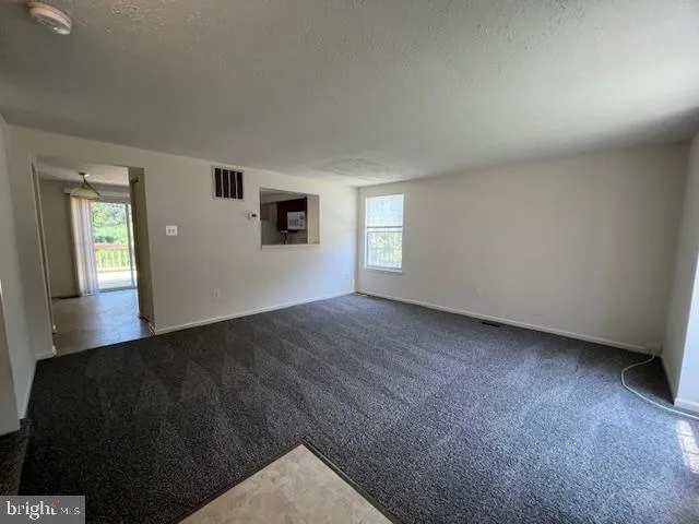 a view of a big room with windows and chandelier fan