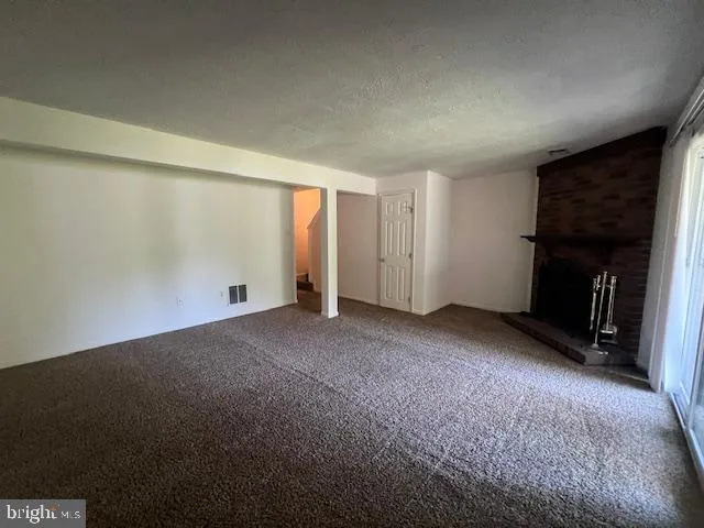 a view of an empty room with a fireplace