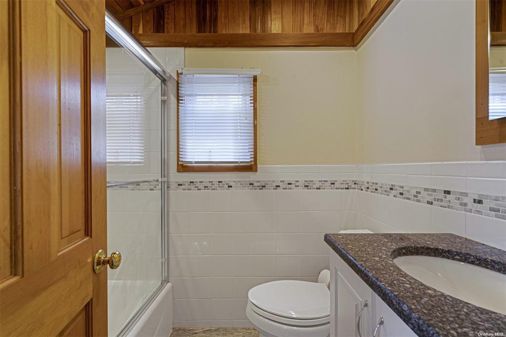 168 West Tiana Road Hampton Bays, NY 11946 - Photo 11 of 17 a bathroom with a granite countertop sink toilet and shower