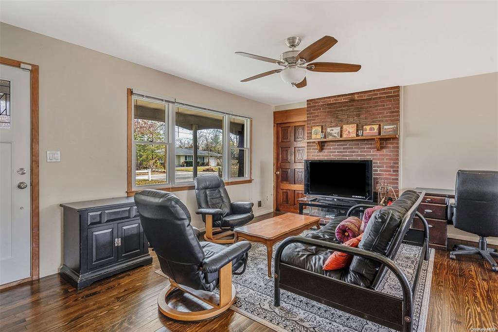 168 West Tiana Road Hampton Bays, NY 11946 - Photo 4 of 17 a living room with furniture a flat screen tv and a large window