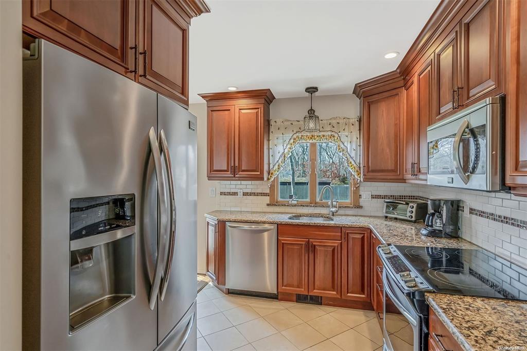 168 West Tiana Road Hampton Bays, NY 11946 - Photo 7 of 17 a kitchen with stainless steel appliances granite countertop a refrigerator a stove and a sink