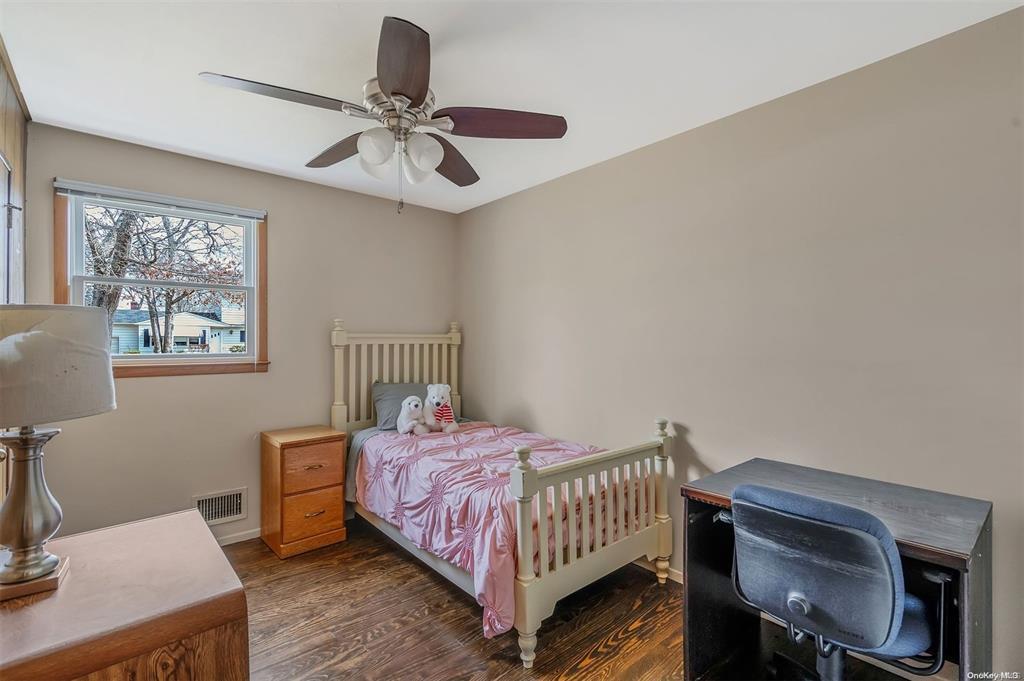 168 West Tiana Road Hampton Bays, NY 11946 - Photo 10 of 17 a bedroom with a bed and a chandelier