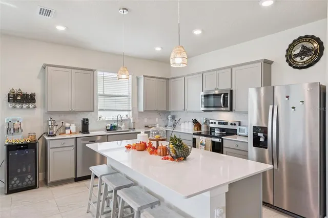 a kitchen with a refrigerator a stove a sink and cabinets