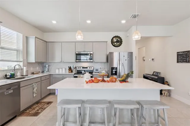 a kitchen with a sink a stove a dining table and chairs