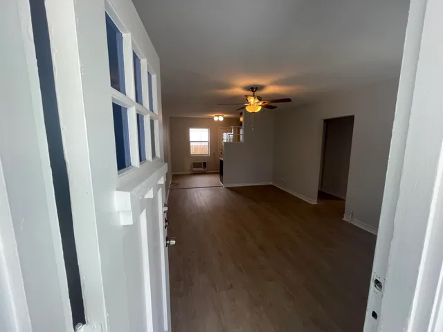 a view of a hallway with wooden floor and staircase