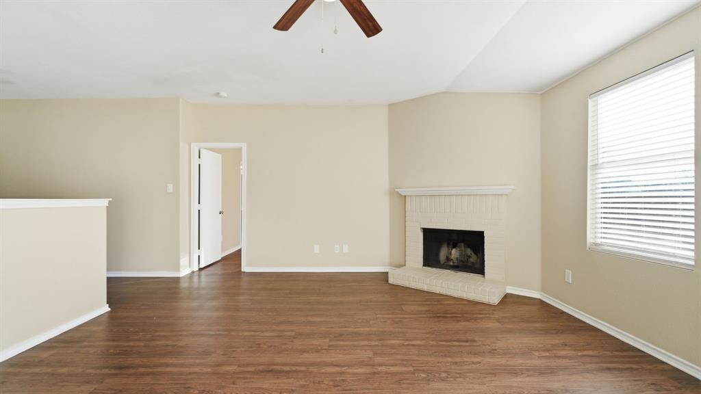 101 Long Prairie Drive Forney, TX 75126 - Photo 15 of 40 a view of empty room with wooden floor and fireplace