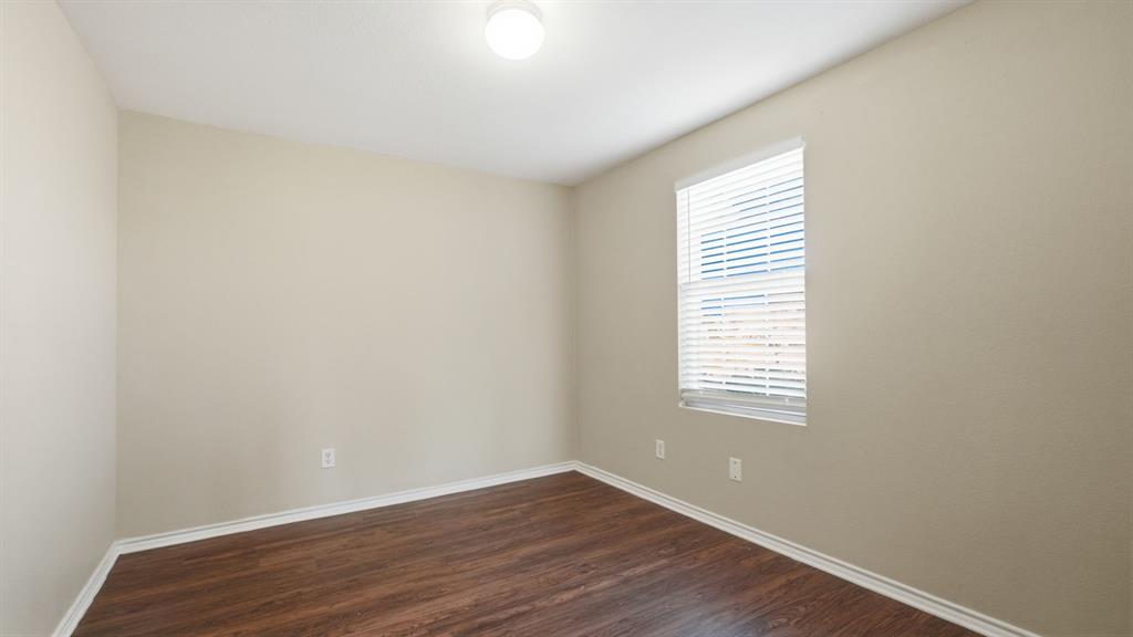 101 Long Prairie Drive Forney, TX 75126 - Photo 21 of 40 a view of an empty room with wooden floor and a window