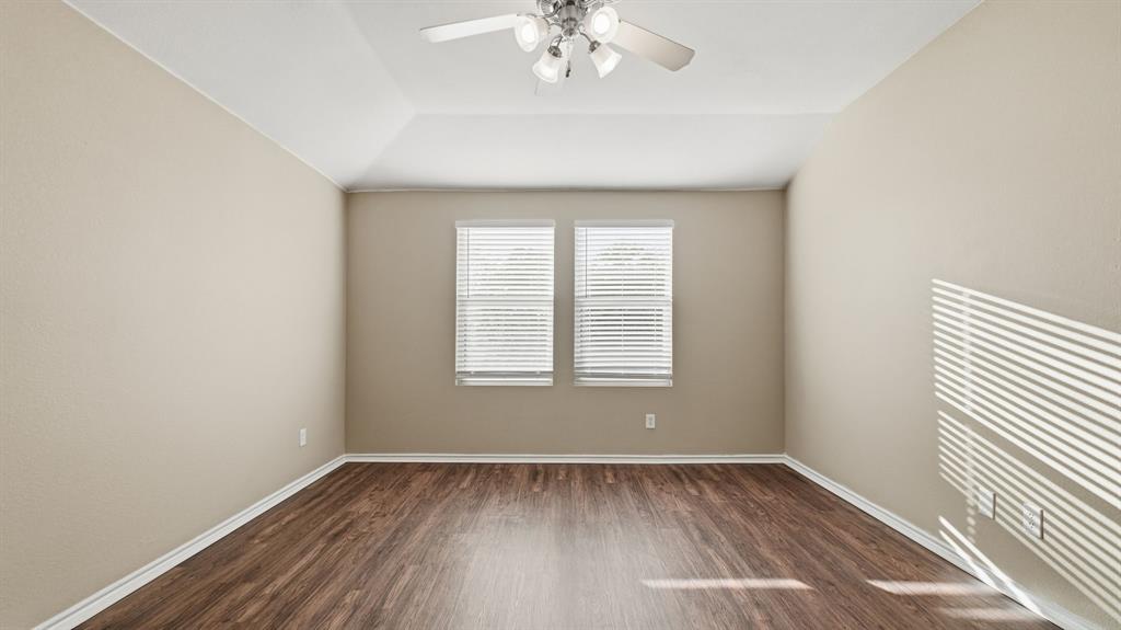 101 Long Prairie Drive Forney, TX 75126 - Photo 24 of 40 an empty room with wooden floor chandelier and window