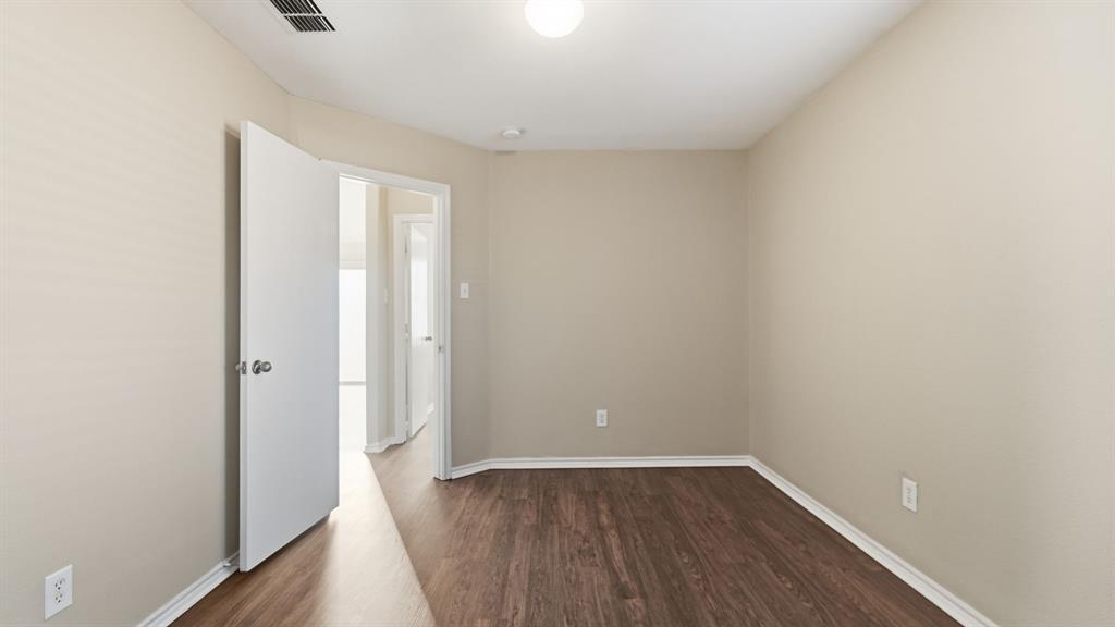101 Long Prairie Drive Forney, TX 75126 - Photo 31 of 40 a view of an empty room with wooden floor and a window