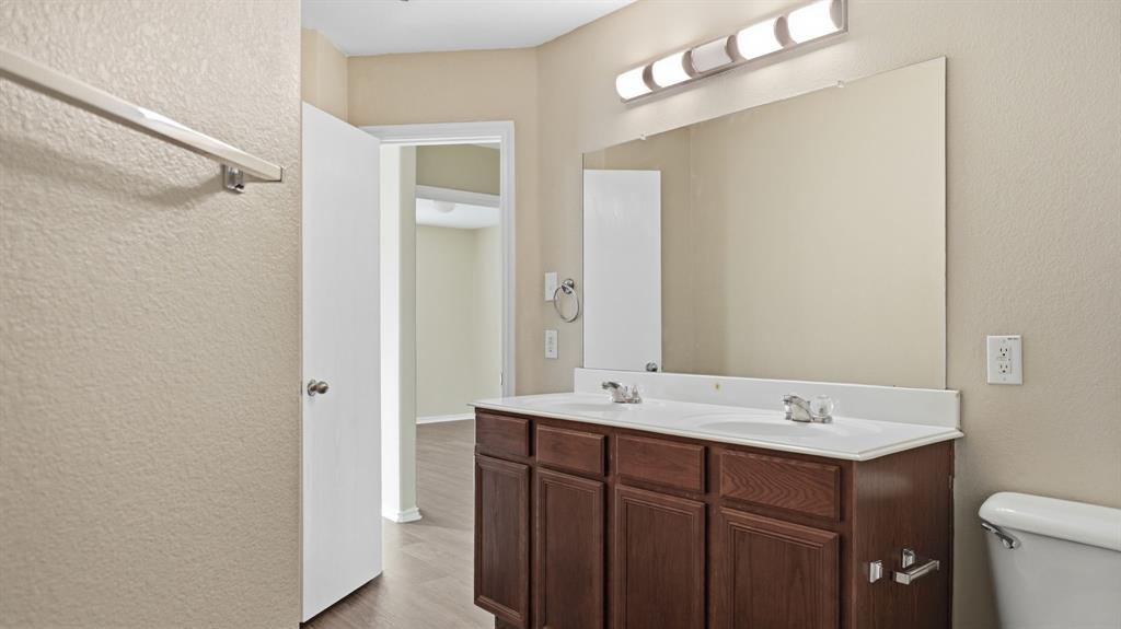 101 Long Prairie Drive Forney, TX 75126 - Photo 35 of 40 a bathroom with a sink a toilet a mirror and shower