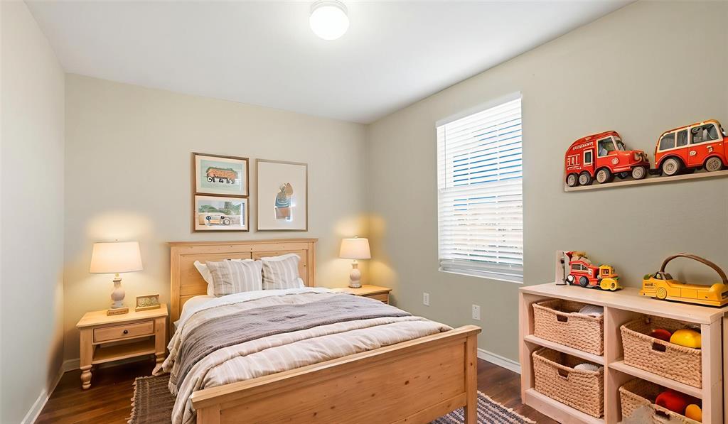 101 Long Prairie Drive Forney, TX 75126 - Photo 7 of 40 a bedroom with a bed and wooden floor