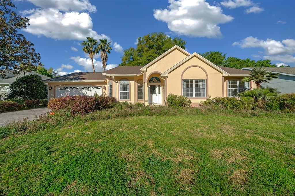 a front view of a house with a yard and potted plants