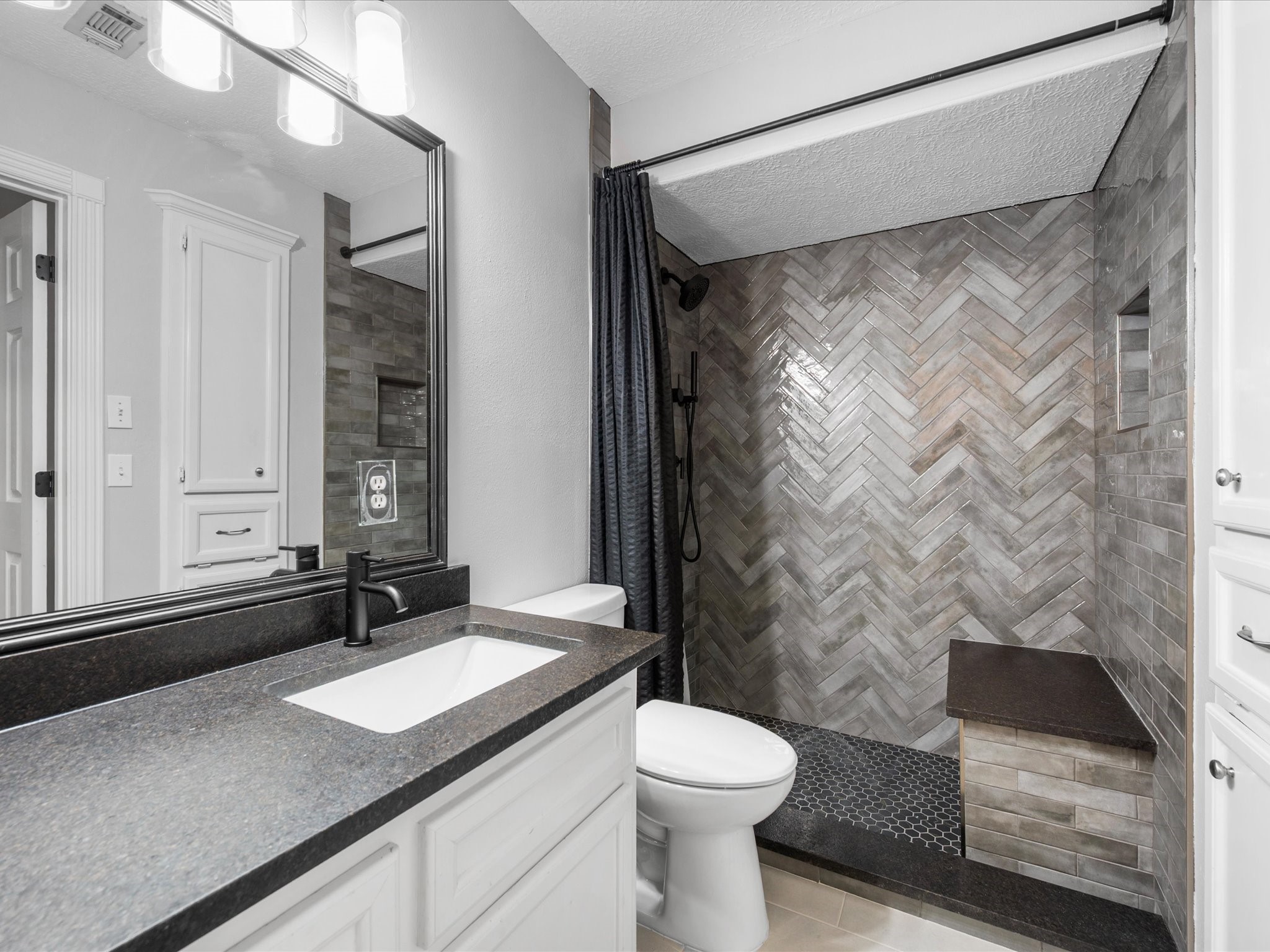 5910 Center Ct Drive Spring, TX 77379 - Photo 34 of 50 A fully updated bathroom featuring a sleek walk-in shower with a built-in bench and modern finishes complements the home’s thoughtfully designed secondary spaces, contributing to a flexible layout ideal for daily living or hosting guests.