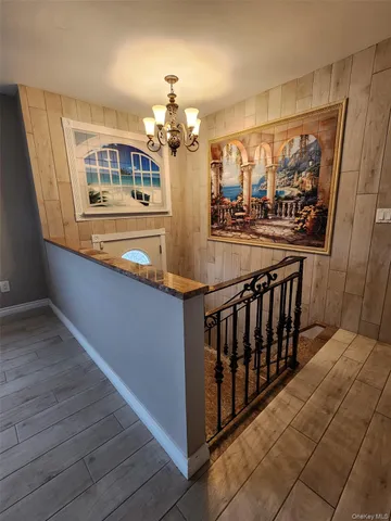 a view of a living room with wooden floor and chandelier