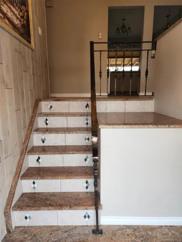 a view of staircase with a rug and a window