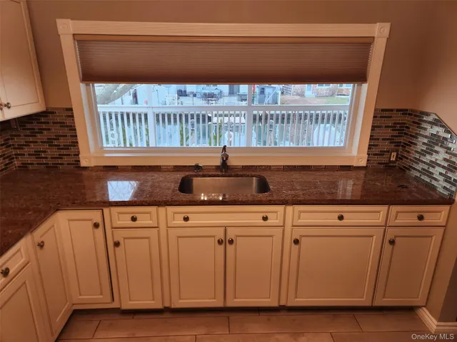 a kitchen with granite countertop white cabinets and sink