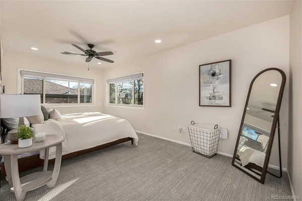 a bedroom with a bed a table and painting on the wall