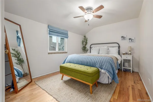 a bedroom with a bed and a mirror on the dresser