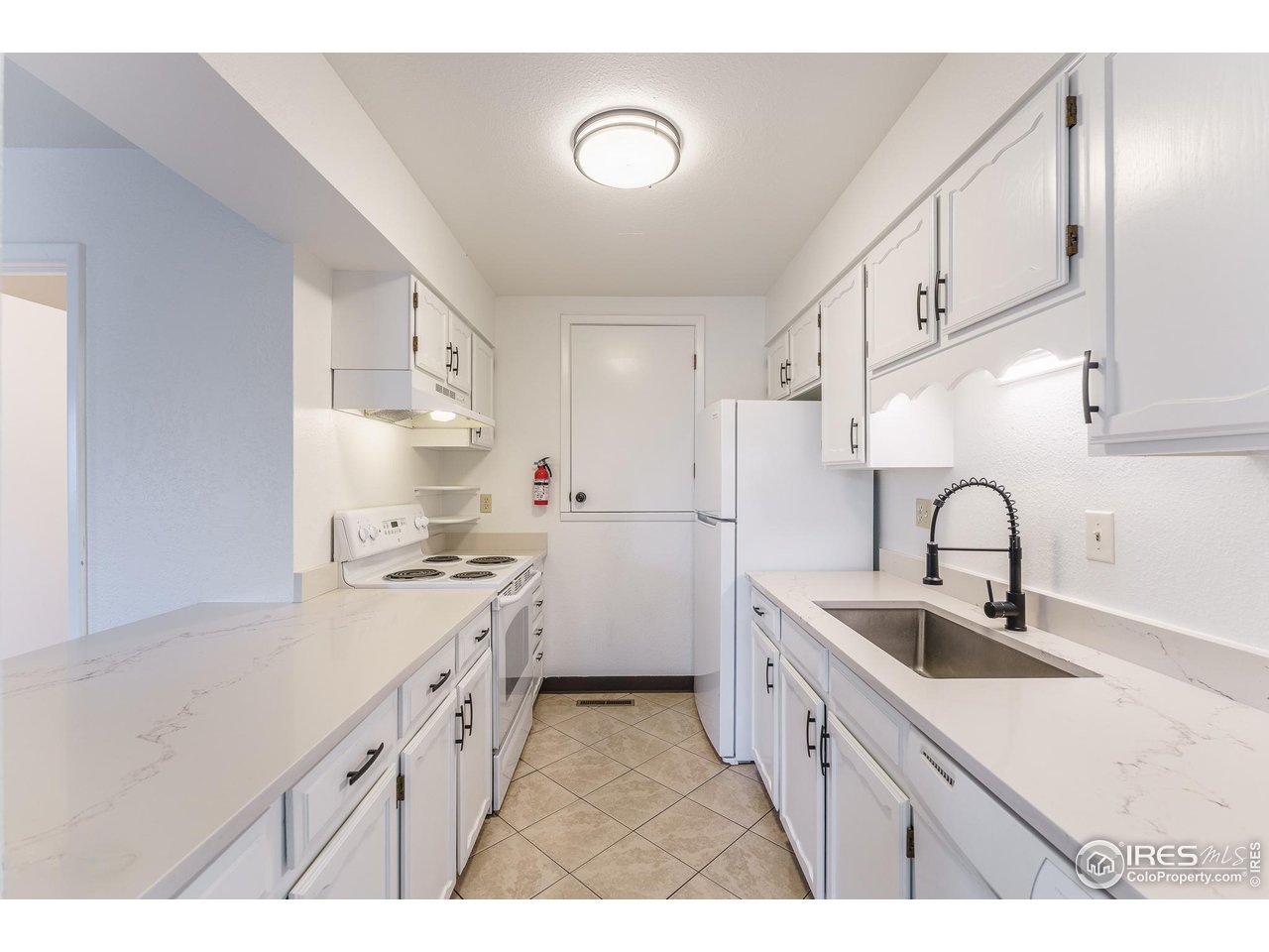 1225 Centaur Circle, Unit A Lafayette, CO 80026 - Photo 5 of 35 a kitchen with white cabinets a sink stove and refrigerator