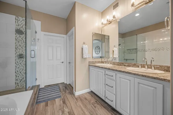 a spacious bathroom with a granite countertop sink a mirror and a shower